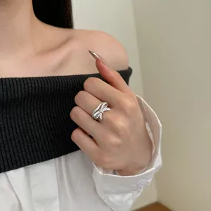 Close-up of a silver bow ring with sparkling zircon stones on a model hand