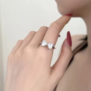 Dettaglio di un anello a fiocco in argento con zirconi bianchi indossato da una modella