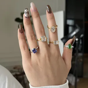 Elegant S925 silver and gold rings with emerald-cut green and blue stones on hand