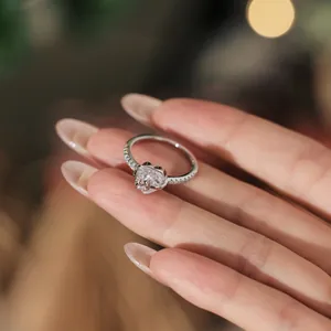 Detailopname van de zilveren ring met hartvormige zirkoon en pavé-zetting op de hand