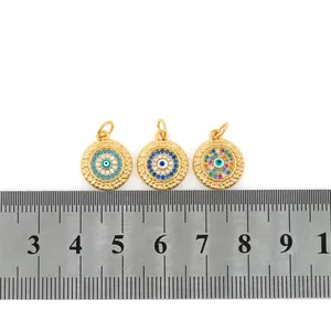 Makroaufnahme von 18K vergoldeten Evil Eye Anhängern mit Zirkonia-Inlay und Maßstab
