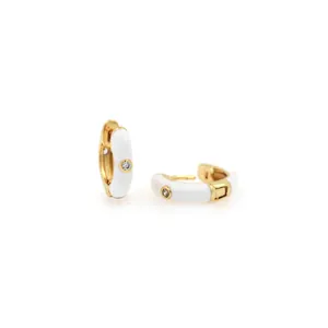 Detail von 18K vergoldeten Huggie-Hoops mit weißer Emaille und Zirkonia-Stein