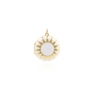 Detailed view of round 18K gold plated sunburst locket with white enamel on white background