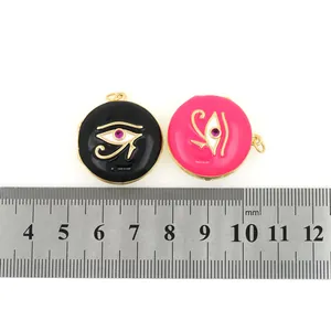Macro shot of 18K gold plated evil eye charms in pink and black with 25mm measurement scale