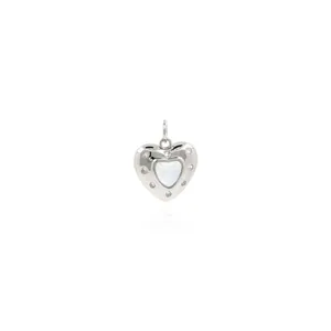 Macro view of silver heart pendant with mother-of-pearl inlay and sparkling crystals