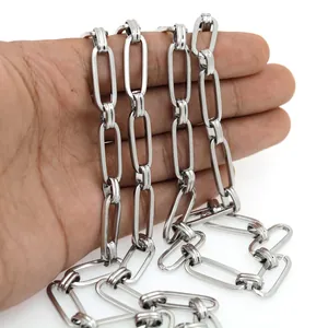 Detail of silver long oval link chain held in hand to show size and polished metal texture