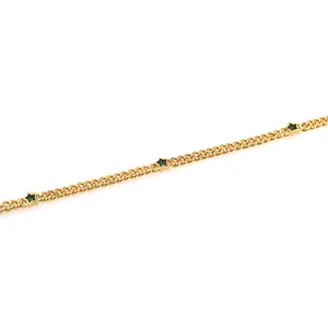 Détail d'une chaîne plate plaquée or 18K avec pierres précieuses vertes en étoile
