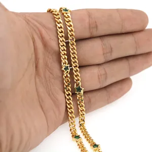 Détail d'une chaîne plate plaquée or 18 carats avec pendentifs étoiles vertes