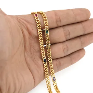 Détail de chaîne gourmette plaquée or 18 carats avec gemmes poire rouges, vertes et bleues