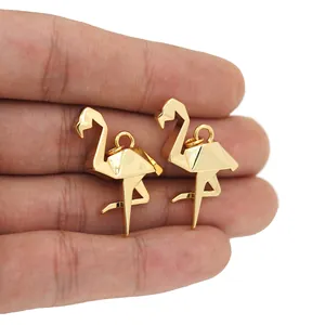 Close-up of a pair of gold-plated flamingo pendants featuring modern geometric origami style