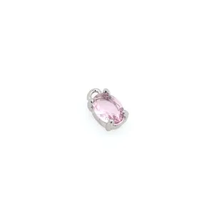Macro shot of oval pink gemstone pendant with silver four-prong setting and bail connector