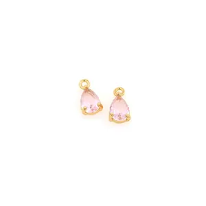 Dettaglio di due ciondoli in cristallo rosa a forma di pera con montatura placcata oro 18K