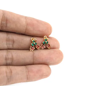 Detail van 18K vergulde hulstblad hanger met rood emaille en groene kristallen decor