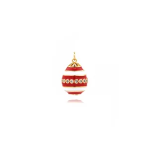 Macro view of egg-shaped pendant with red and white enamel and inlaid zircons