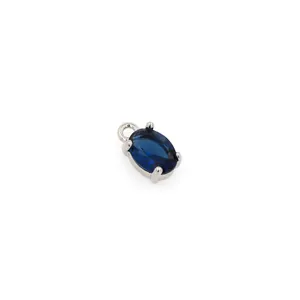 Detailed macro view of an oval dark blue zircon pendant with silver four-prong setting