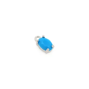 Detailed view of an oval blue turquoise pendant with 18K gold plated silver 4-prong setting