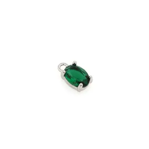 Detailed macro view of an oval faceted green emerald pendant with 18K gold-plated setting