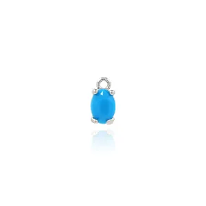 Macro shot of oval blue turquoise stone pendant set in silver four-prong mount