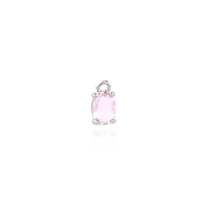 Detailed view of an oval pink gemstone pendant with silver four-prong setting and top loop