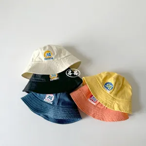 Detailed top view of kids cotton bucket hats in five colors with holiday emblems