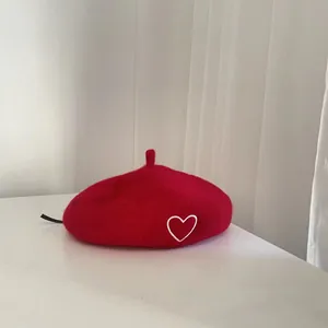 Classic red wool beret for kids featuring a delicate white heart embroidery detail