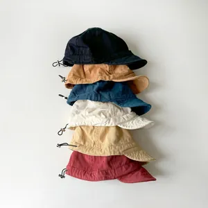Detail view of adjustable drawstrings and six color options for the children's cotton cap