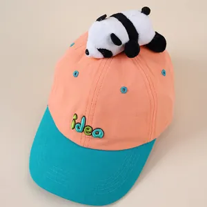 Detail einer Kinder-Baseballkappe mit Plüsch-Pandapuppe und gesticktem Idea-Schriftzug