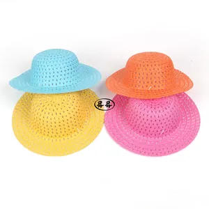 Détail de quatre chapeaux de paille colorés pour DIY enfants en bleu, orange et rose