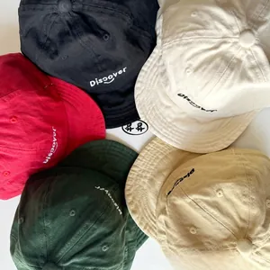 Flat lay of cotton baseball caps in black, cream, red, green and khaki with embroidery