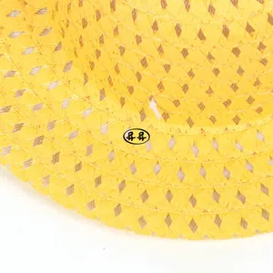 Gros plan d'un chapeau de soleil jaune avec des motifs de tissage en losange ajourés