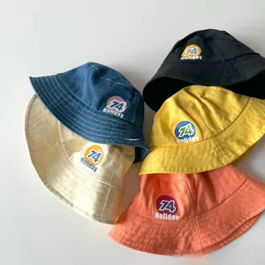 Detail showing five colors of kids bucket hats with Holiday 74 prints on cotton fabric