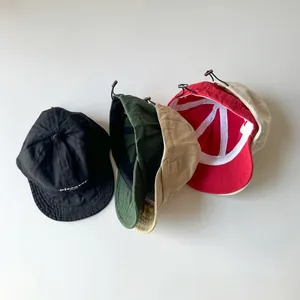 Detail view of colorful cotton baseball caps with adjustable drawstrings and embroidery