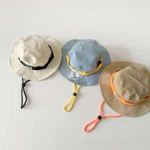 Three outdoor bucket hats in cream, blue, and khaki with adjustable drawstrings