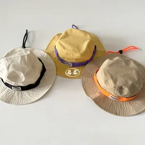 Detail view of outdoor kids sun hats in beige, yellow, and khaki with adjustable wind cords