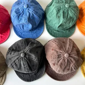 Berretti da baseball in cotone lavato per neonati in sette colori diversi disposti in piano