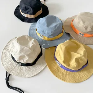 Flat lay of colorful kids sun hats with adjustable windproof cords in five vibrant colors