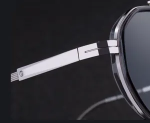 Detailed close-up of high-quality silver metal screwless hinge on polygon sunglasses