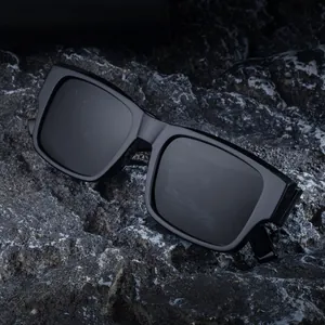 Classic black square polarized sunglasses for men with large frame on dark volcanic rock