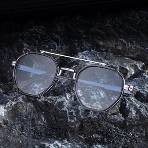 Modern double bridge polygon sunglasses with metallic frames on a textured rock surface