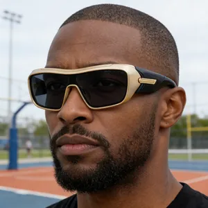 Detail of men's sporty sunglasses with gold and black frames on an outdoor basketball court