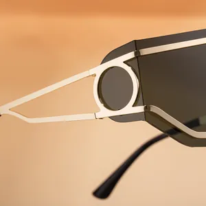 Dettaglio della cerniera in metallo dorato e design circolare degli occhiali punk