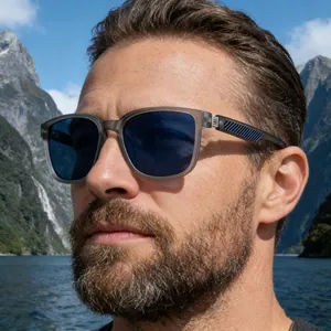 Detalle de gafas de sol polarizadas cuadradas en modelo con montañas nevadas al fondo