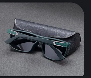 Détail de lunettes de soleil carrées avec monture verte et étui en cuir noir