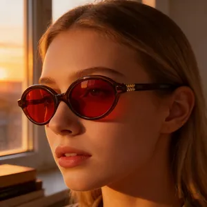 Close-up of retro oval sunglasses with red lenses and amber frame on model