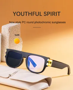 Close-up of square photochromic sunglasses with gold accents on a textured rock base