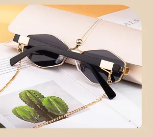 Polygonal sunglasses with gold chain and beige leather pouch on magazine