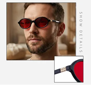 Detailed close-up of retro black oval sunglasses with red lenses and golden embossed temples