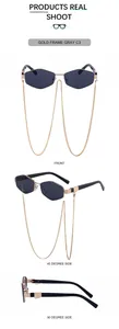 Detail view of gold polygon sunglasses with gray lenses and decorative gold neck chain
