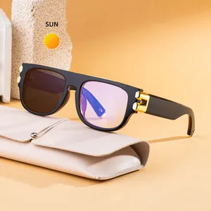 Fashionable square frame photochromic sunglasses in black and gold on a stone block