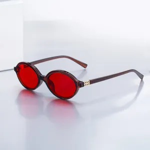 Fashionable oval sunglasses with red lenses and translucent amber frames for women